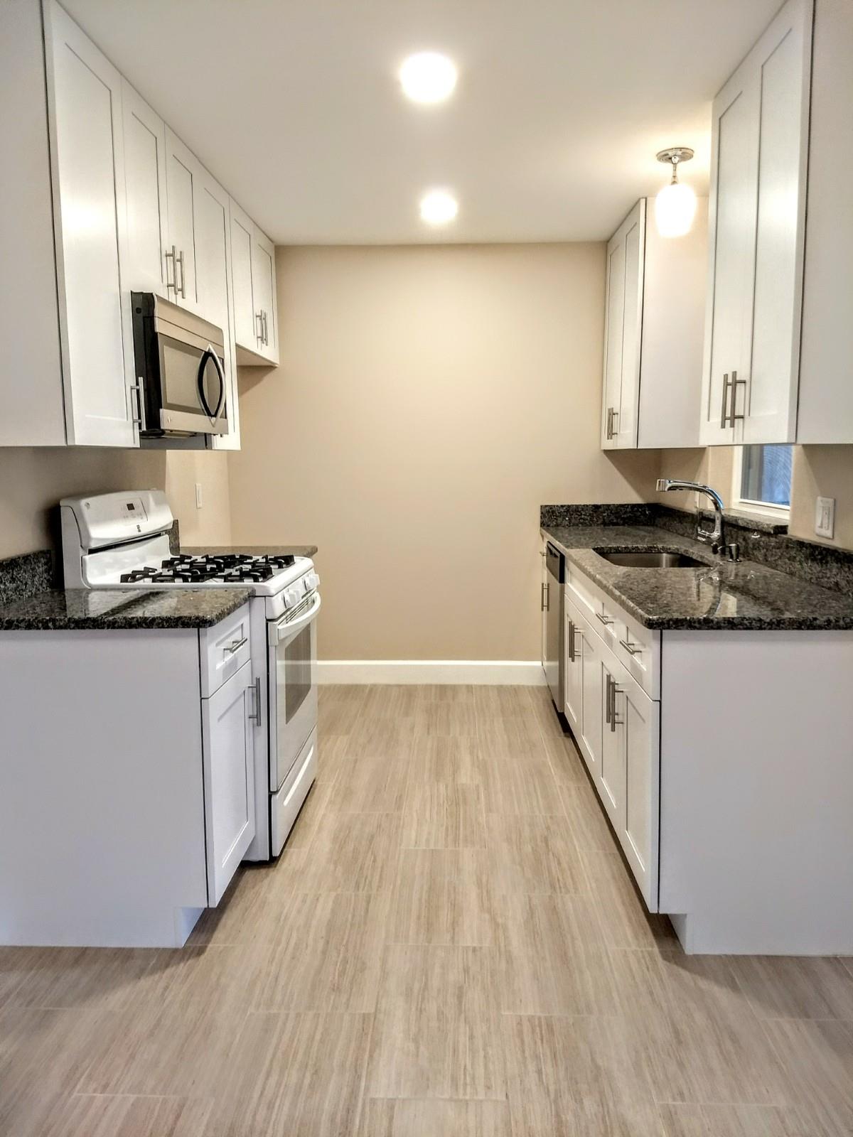 Renovated kitchen - granite counters white cabinets new floors