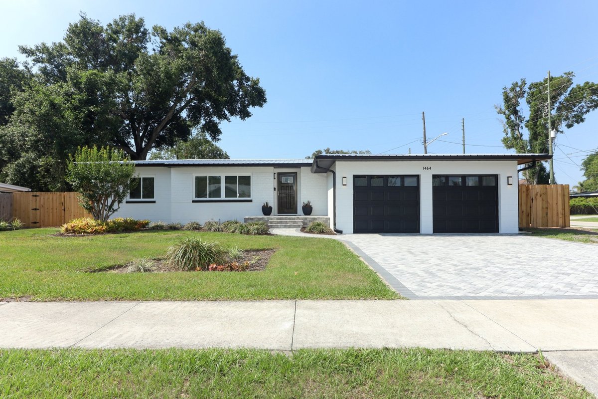 College Park Orlando FL home after full renovation and addition by Star Home Solutions - white painted brick, black trim, new metal roof, paver driveway