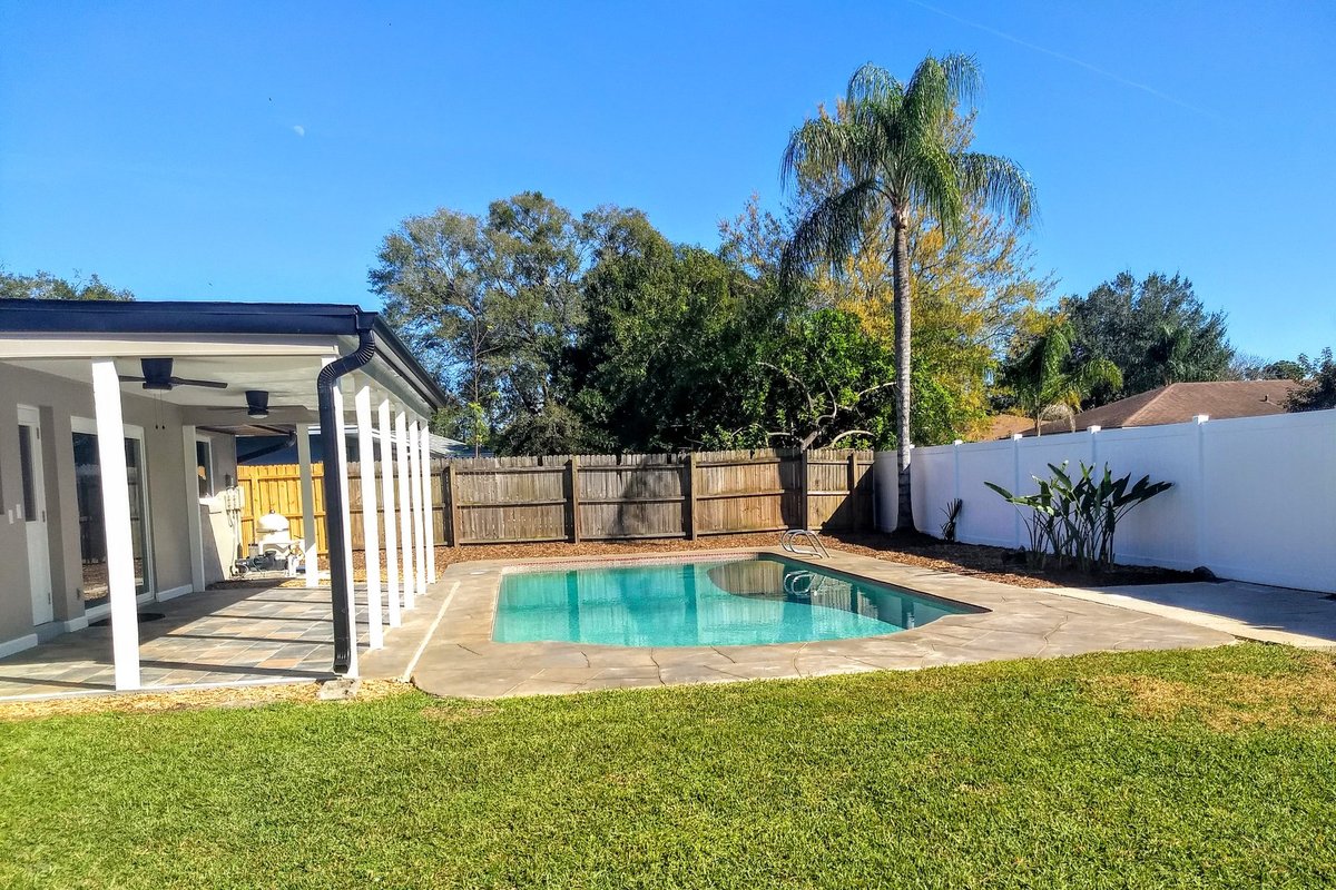Altamonte Springs FL pool home backyard after renovation by Star Home Solutions - sparkling pool, stamped concrete deck, new sod, covered lanai